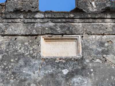 Poco pi� in basso infine � incassata una targa in pietra che fa memoria del restauro del campanile avvenuto nel 1877 per volere di tale Nicola Troiano
